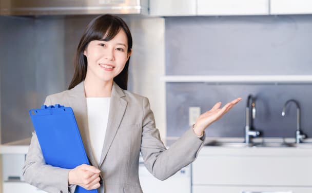 スーツ姿で微笑みながら案内する女性