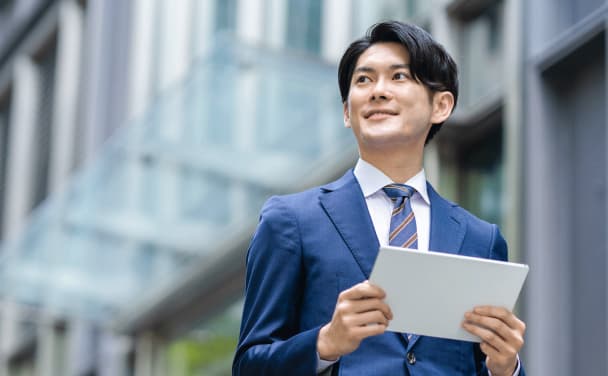 屋外で手に書類を持つ男性社員